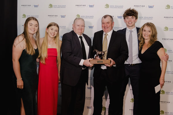 Warwick Jeffries, flanked by his family, receives the New Zealand Small Breeder of the Year Award from Novara Park’s Don Edwards Photo: Christine Dawkins