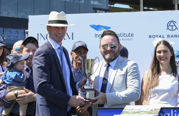 Sebastian Hutch from Inglis presents the winning trophy to Scott Darby after the Inglis Nursery won by within the Law - image Bradley Photography. 