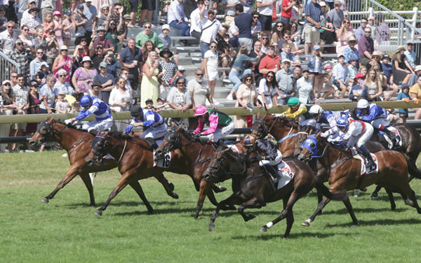 Mai Tai (centre, black colours) bursts to the lead in front of the large crowd on-course at Ellerslie on Boxing Day Photo credit: Trish Dunell 